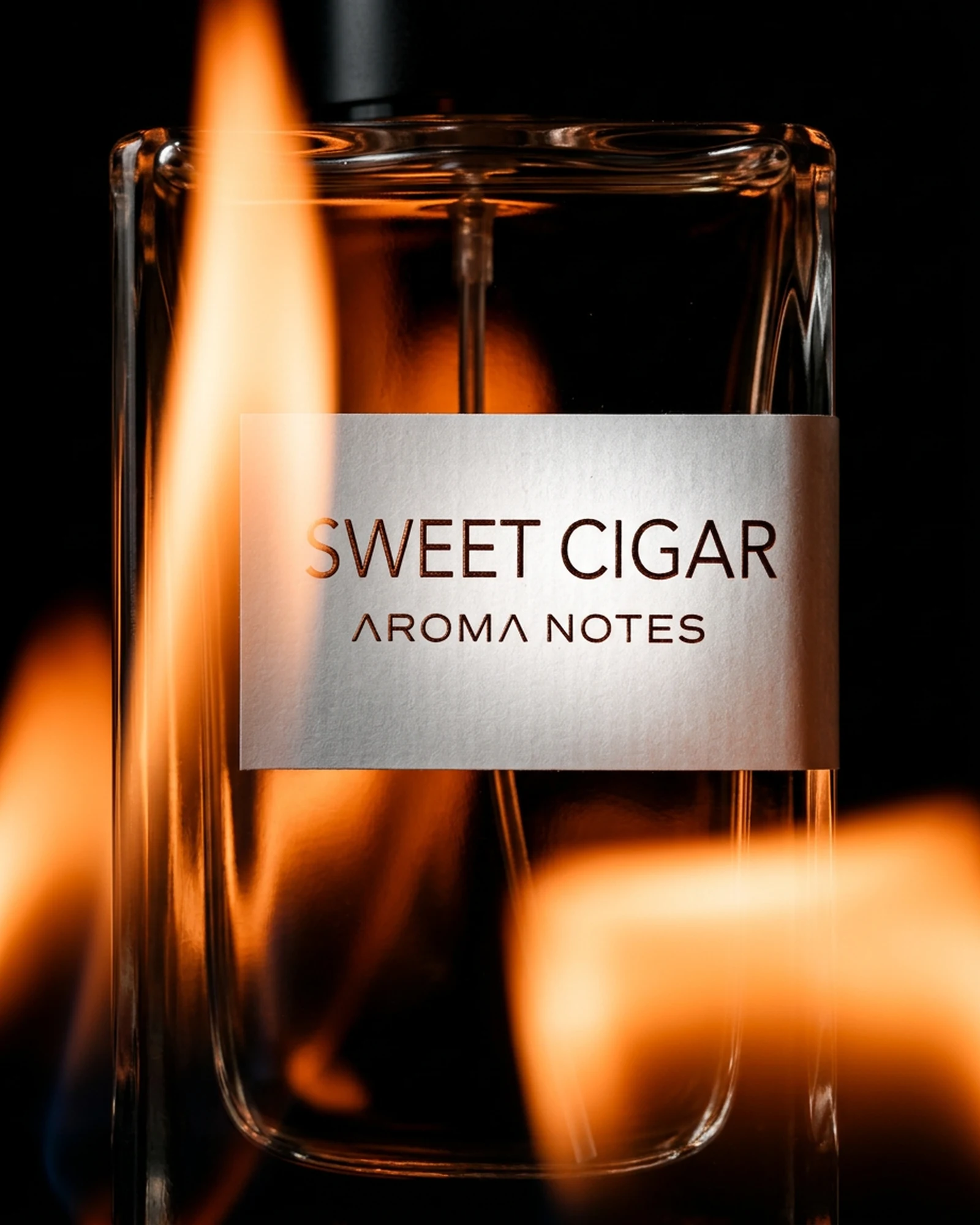 Aroma Notes Sweet Cigar perfume bottle beside open flame